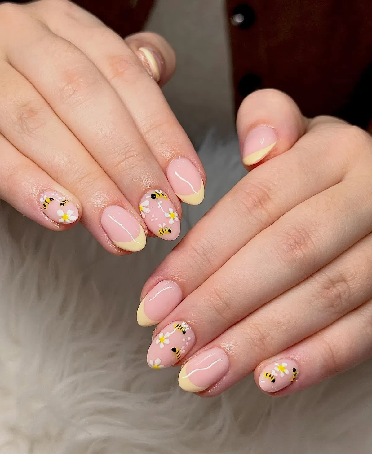 Pale yellow French tips with bees and daisies