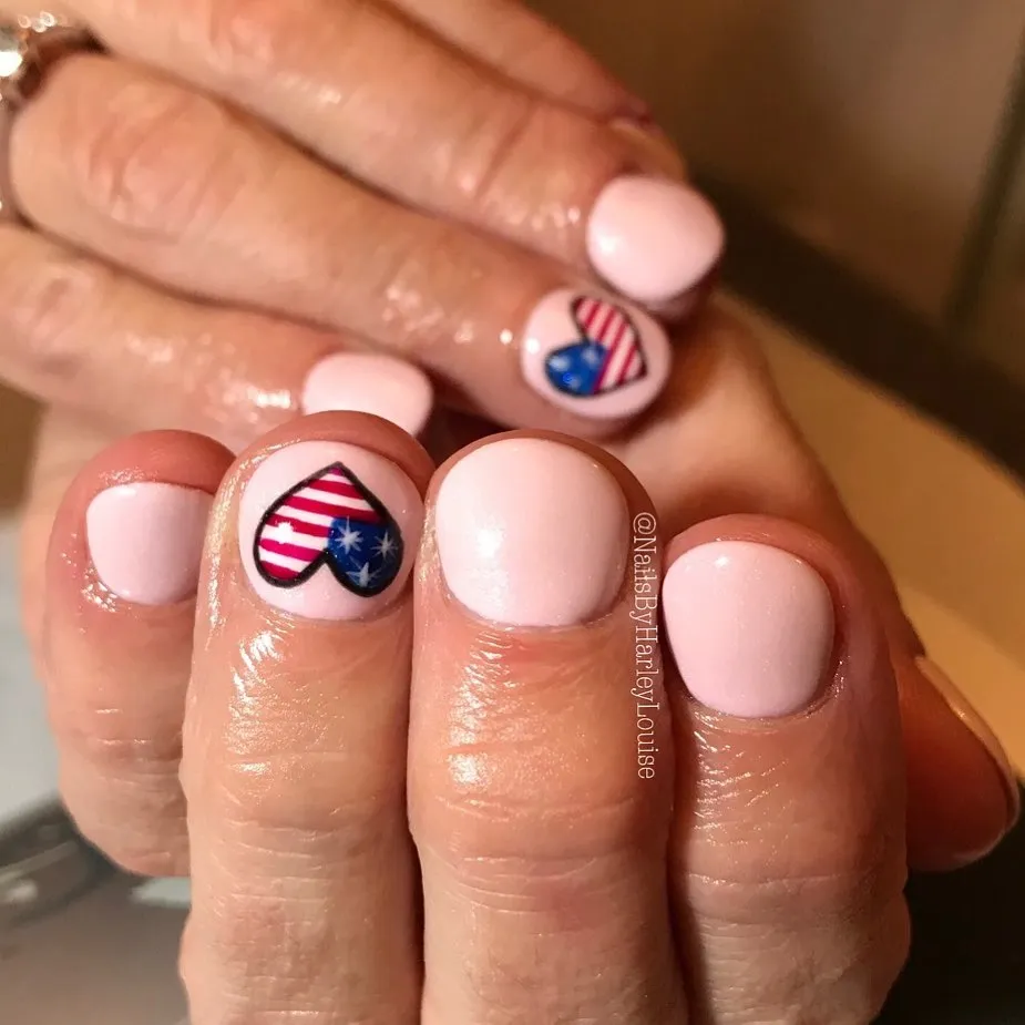 Pale pink nails with heart-shaped stripe-and-star accents