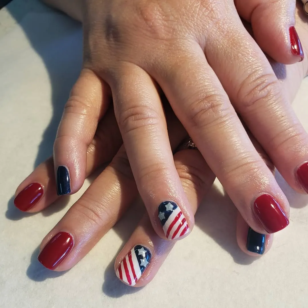 Short red and navy nails with two star-corner stripe accents