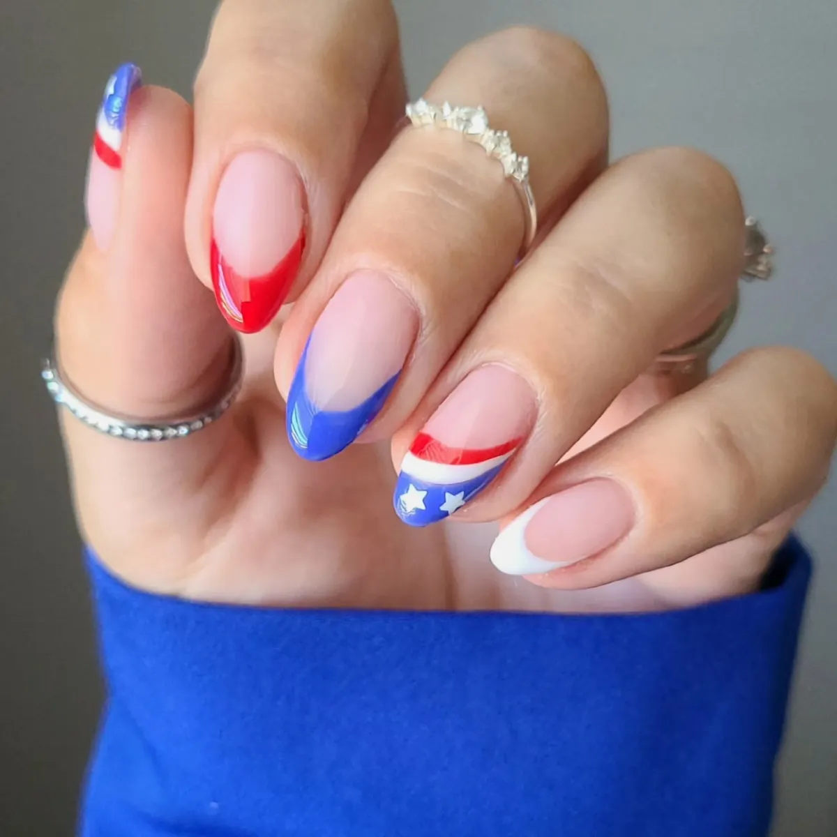 Clean almond French tips in red, blue, and white with star detail