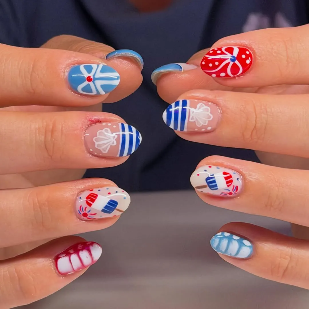Playful red, white, and blue nail art with bows and popsicles