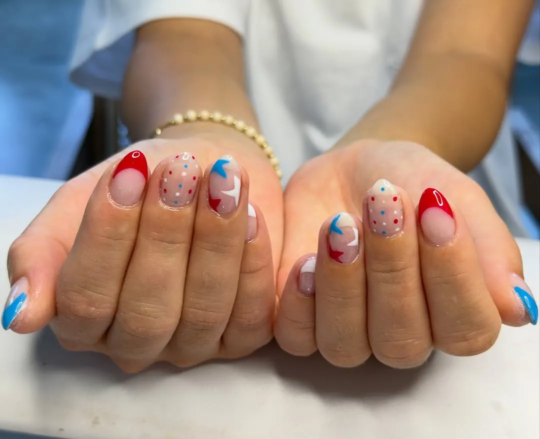 Short rounded French tips with star shapes and dotted accents