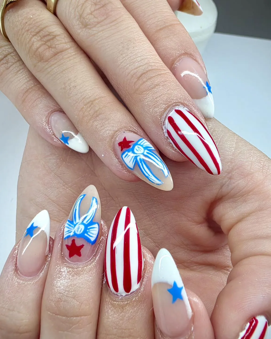 Striped statement nails with blue star tips and bow-like line art