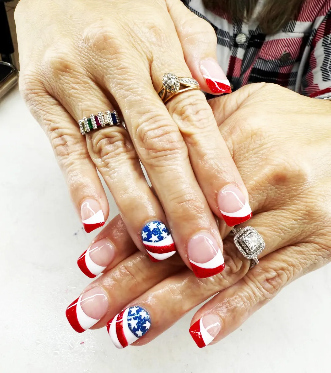Red French tips with curved white bands and star accents