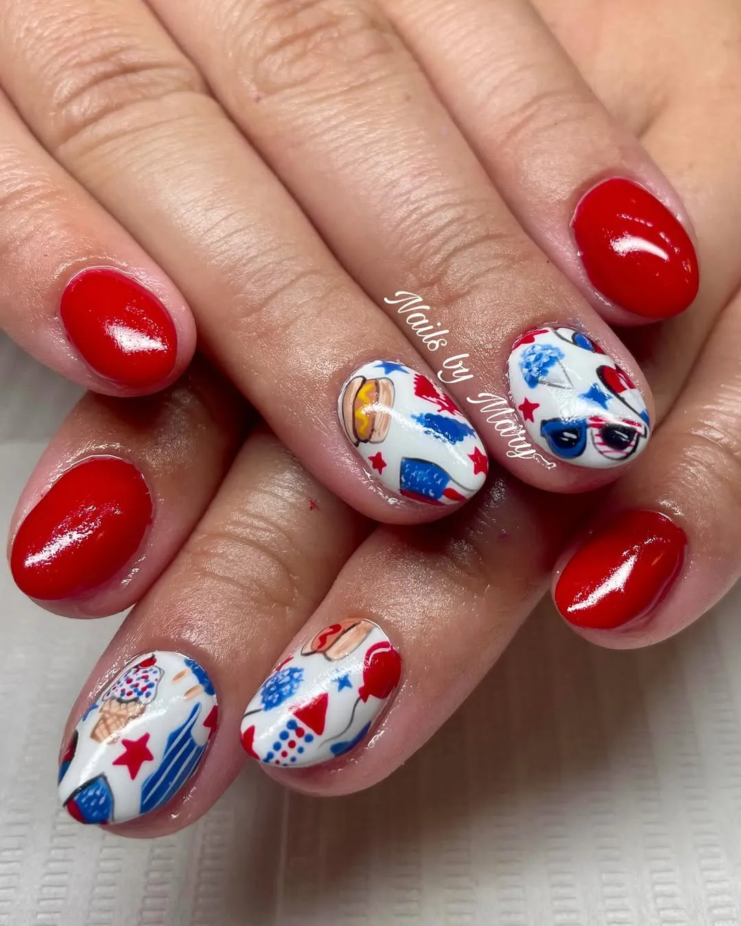 Glossy red nails with white icon-print accents