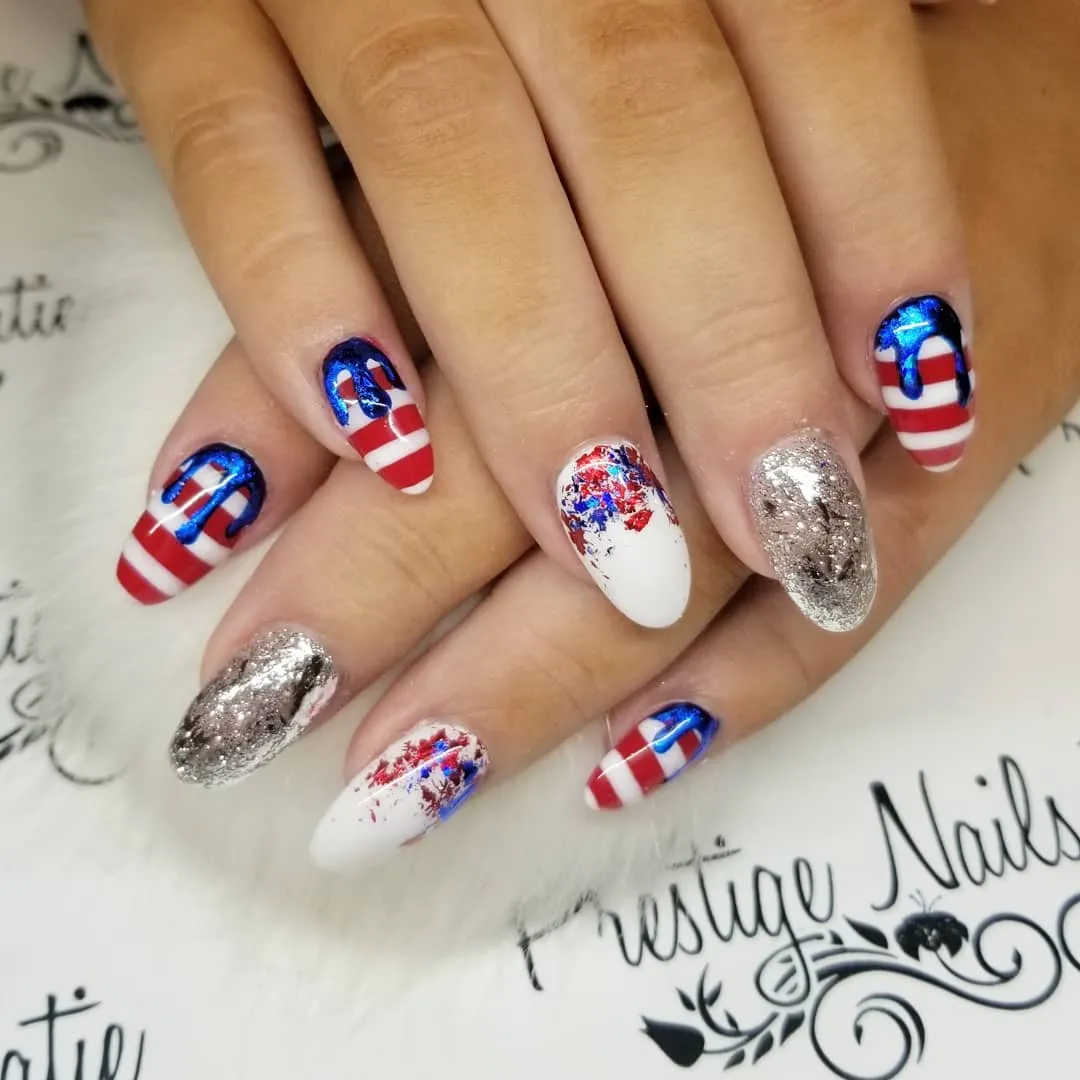 Striped nails with metallic blue drip and silver glitter accents