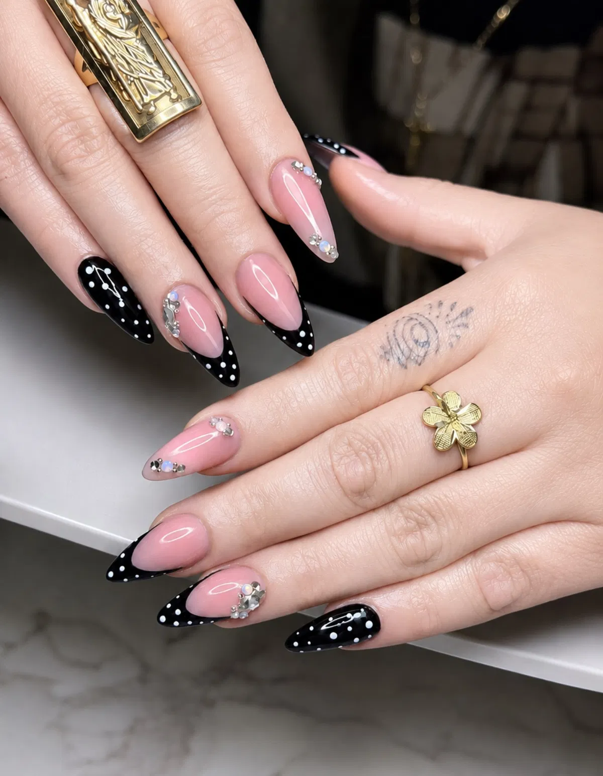 Stiletto black polka-dot French tips with rhinestone accents