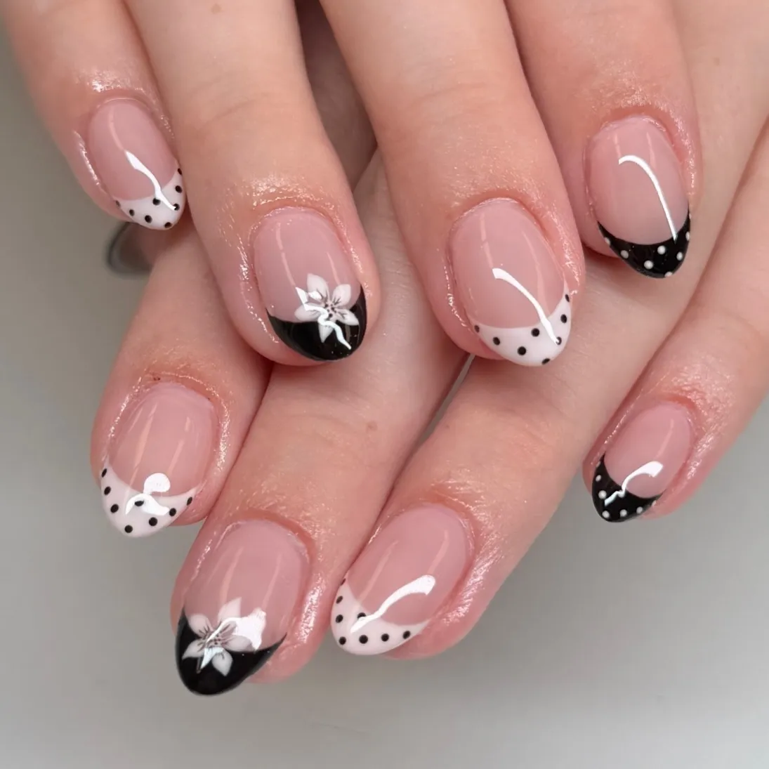 Short polka-dot French tips with white floral accents
