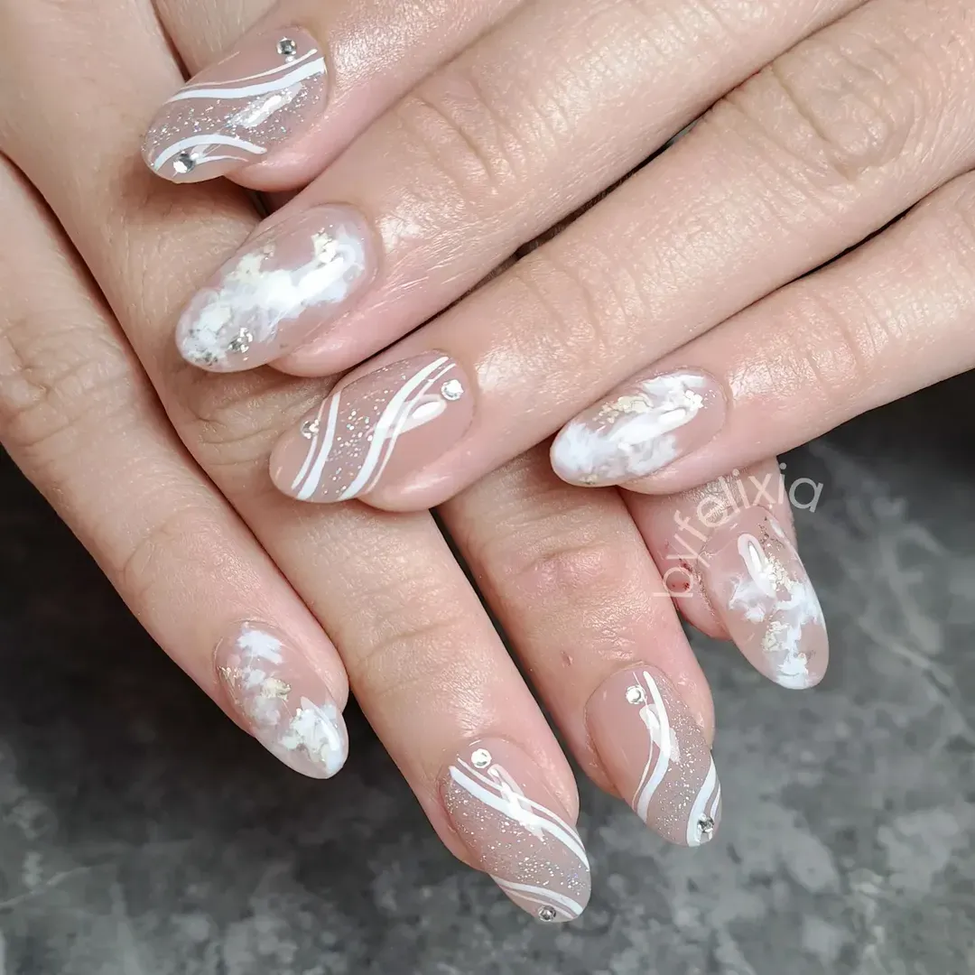 Close-up of nude glitter swirls with rhinestone accents