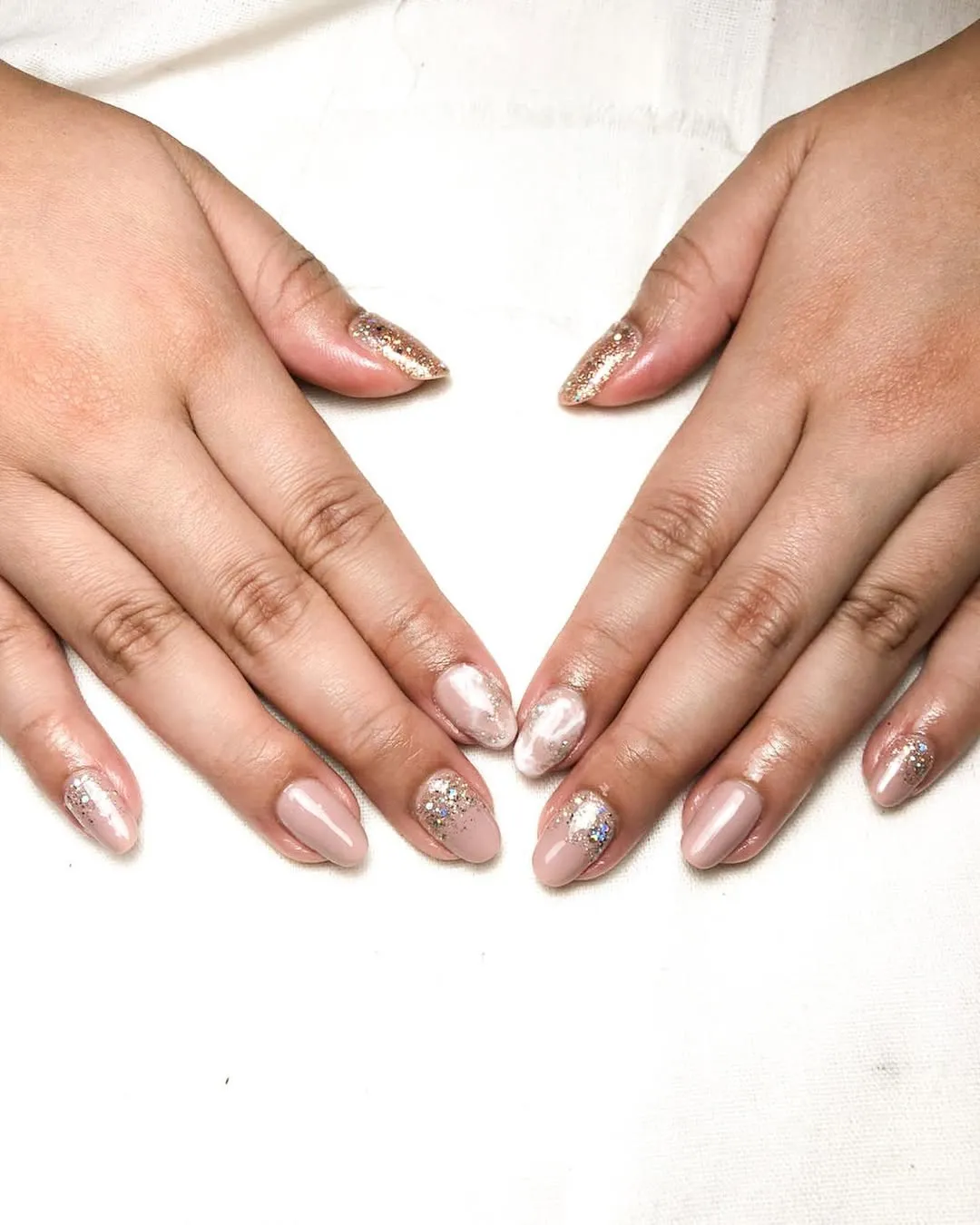 Pale nude with glitter accents and pearly highlight nail