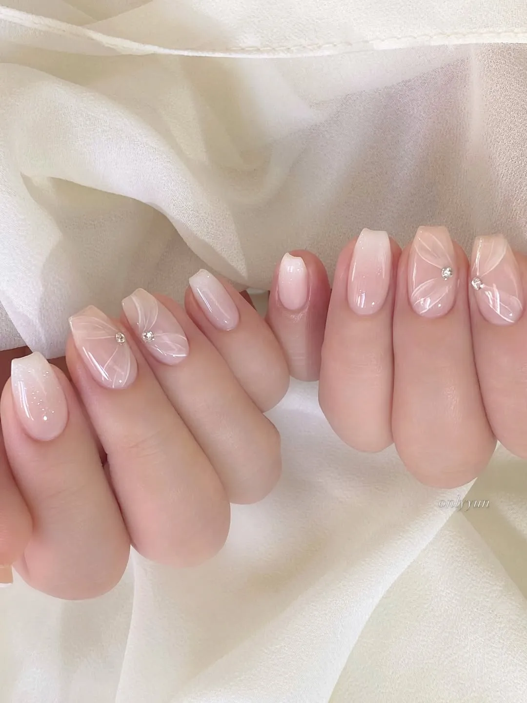 Soft pink gradient with white petal linework and rhinestones