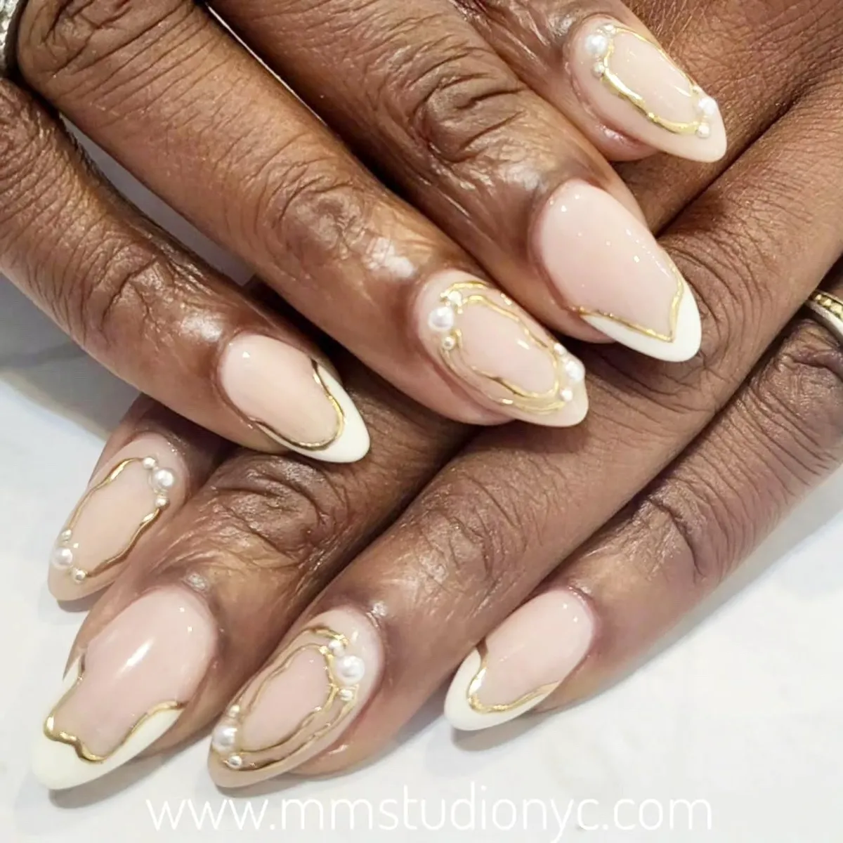 Gold-outlined French tips with pearl accents