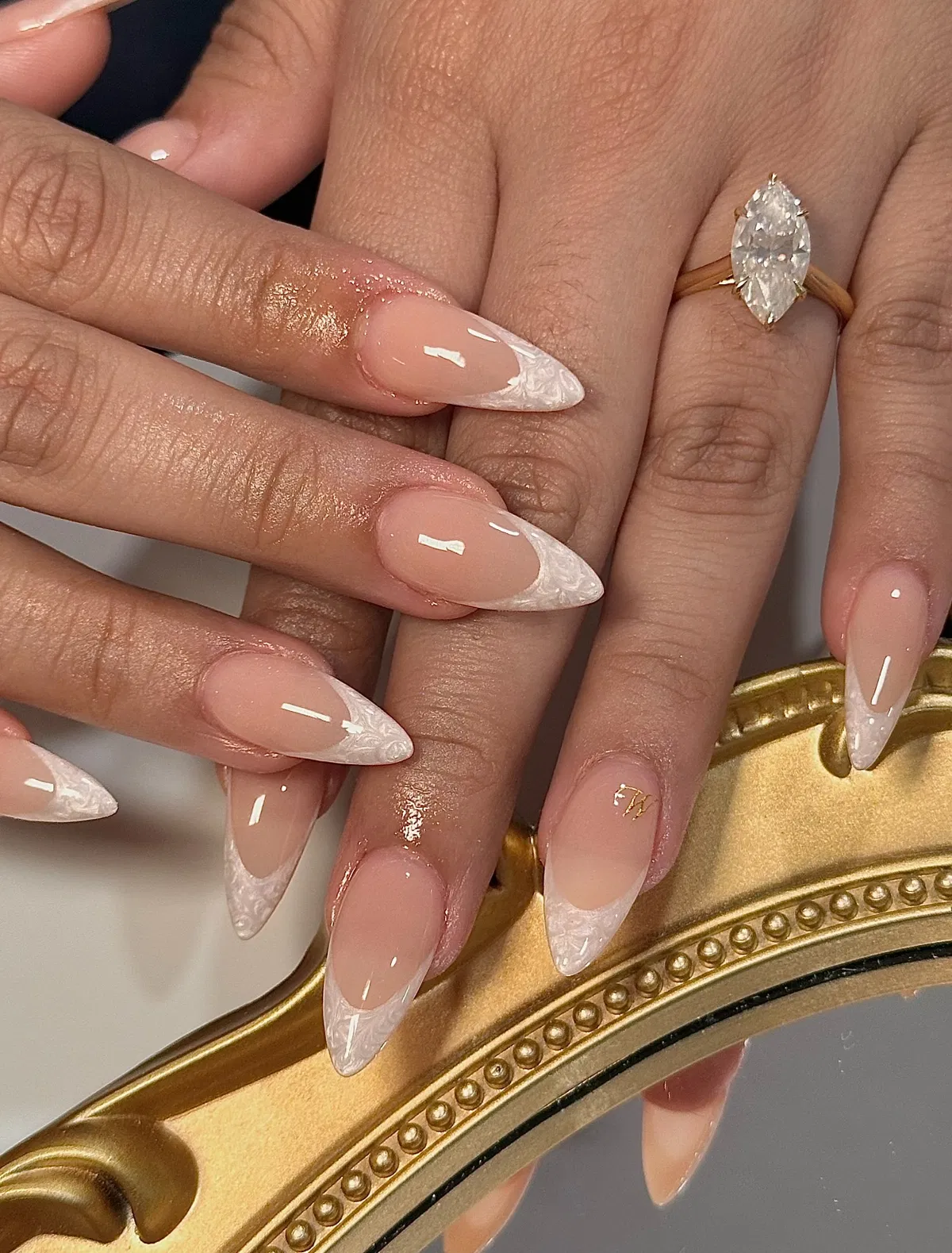 Nude stiletto nails with white marbled French tips