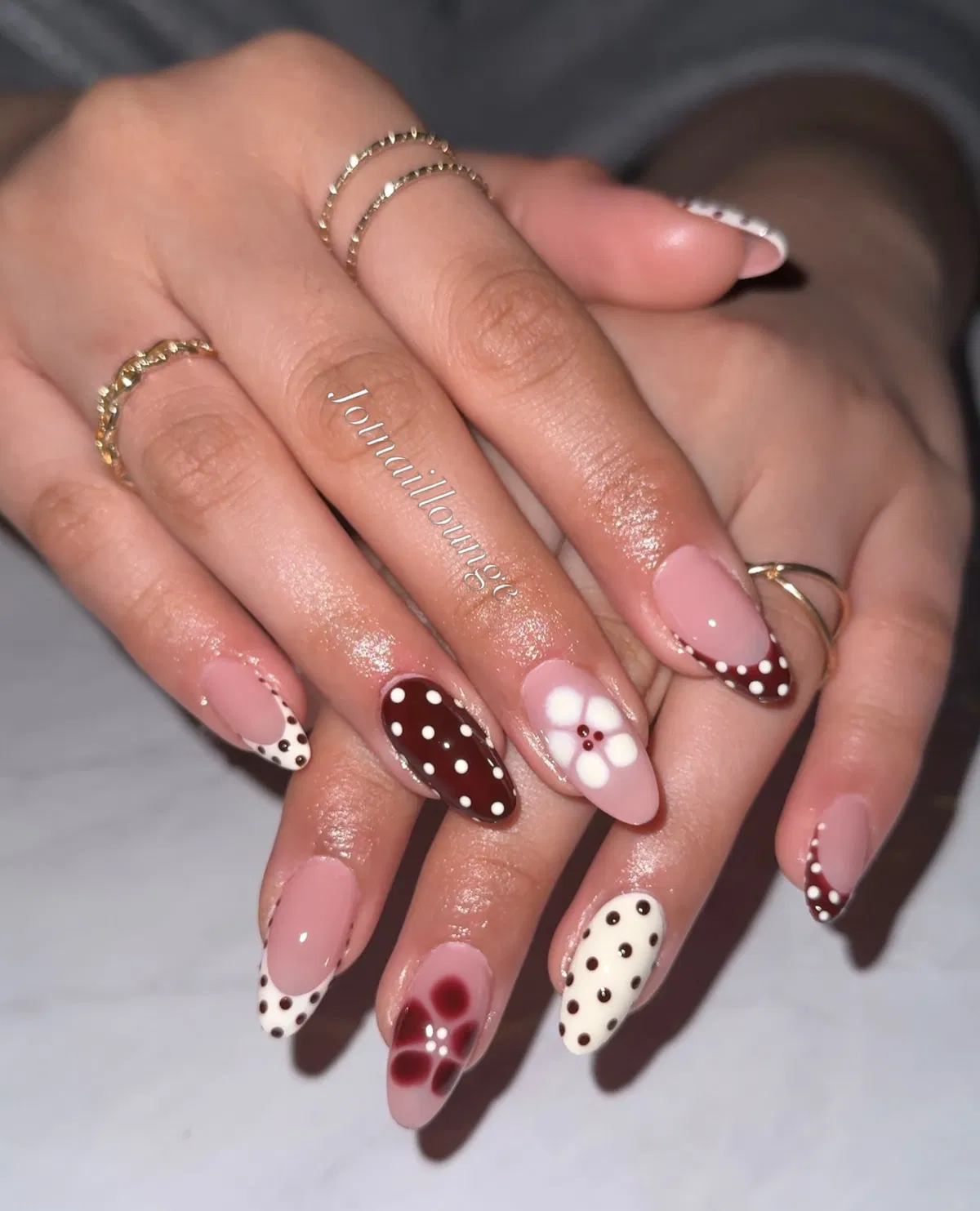 Mixed brown polka dots with white-dot accents and a flower nail