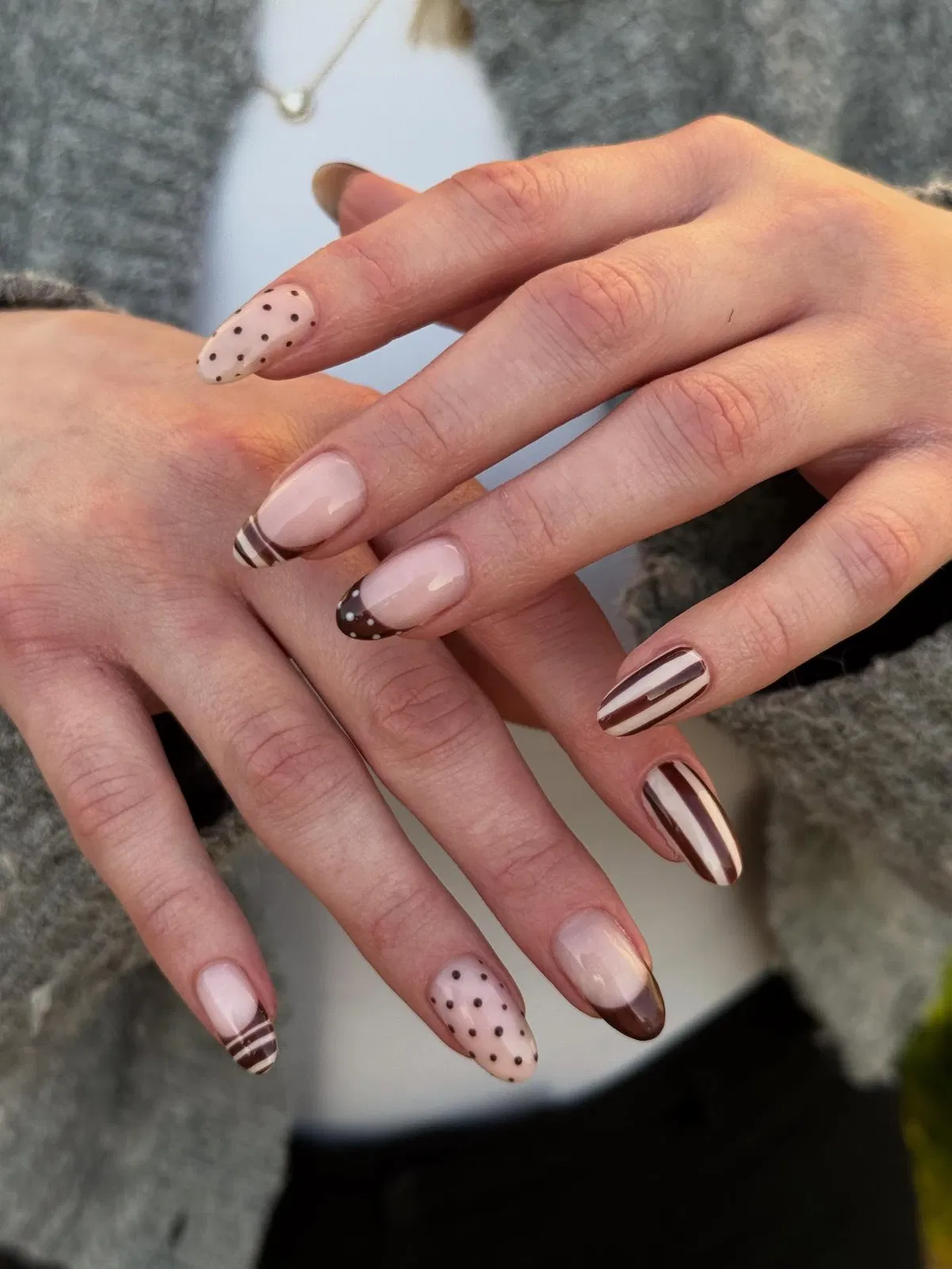 Neutral nude base with brown polka dots, stripes, and gradient tips