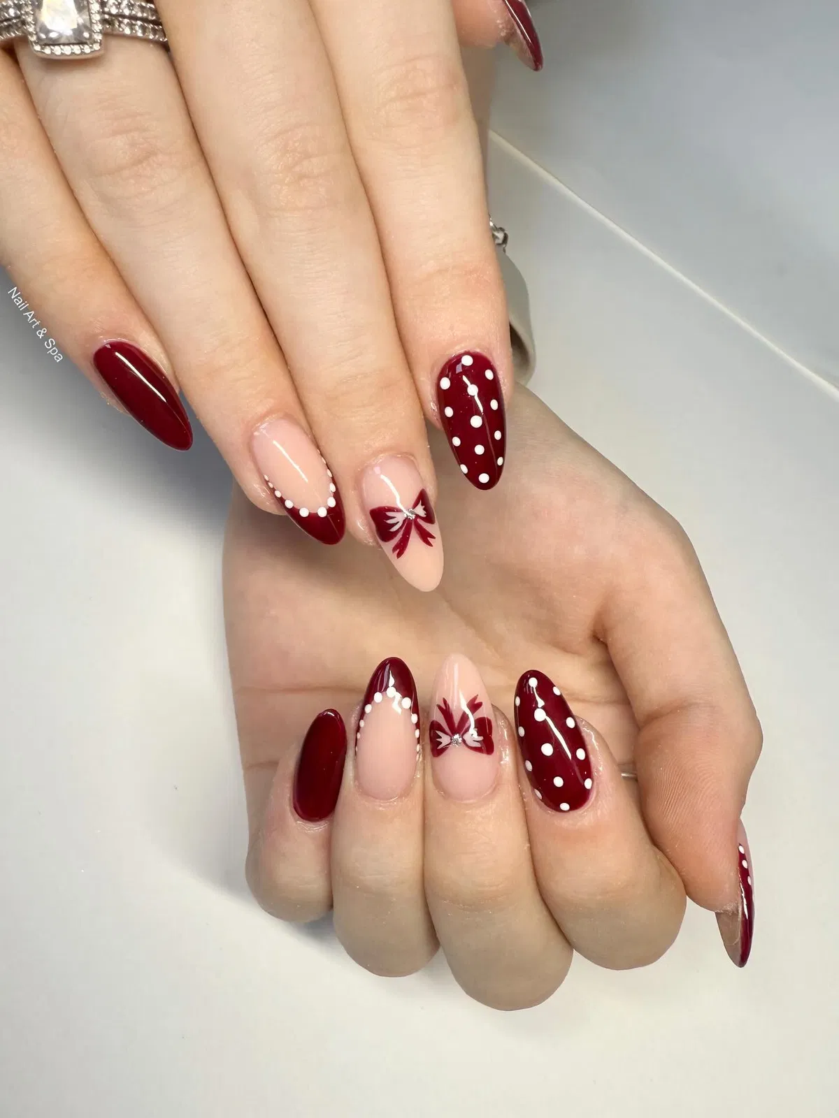 Burgundy polka dots with bow nail art