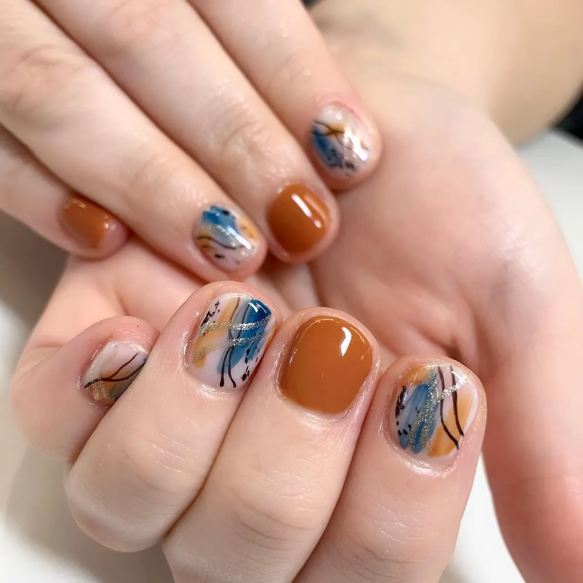 Short burnt orange with abstract blue-and-silver accents