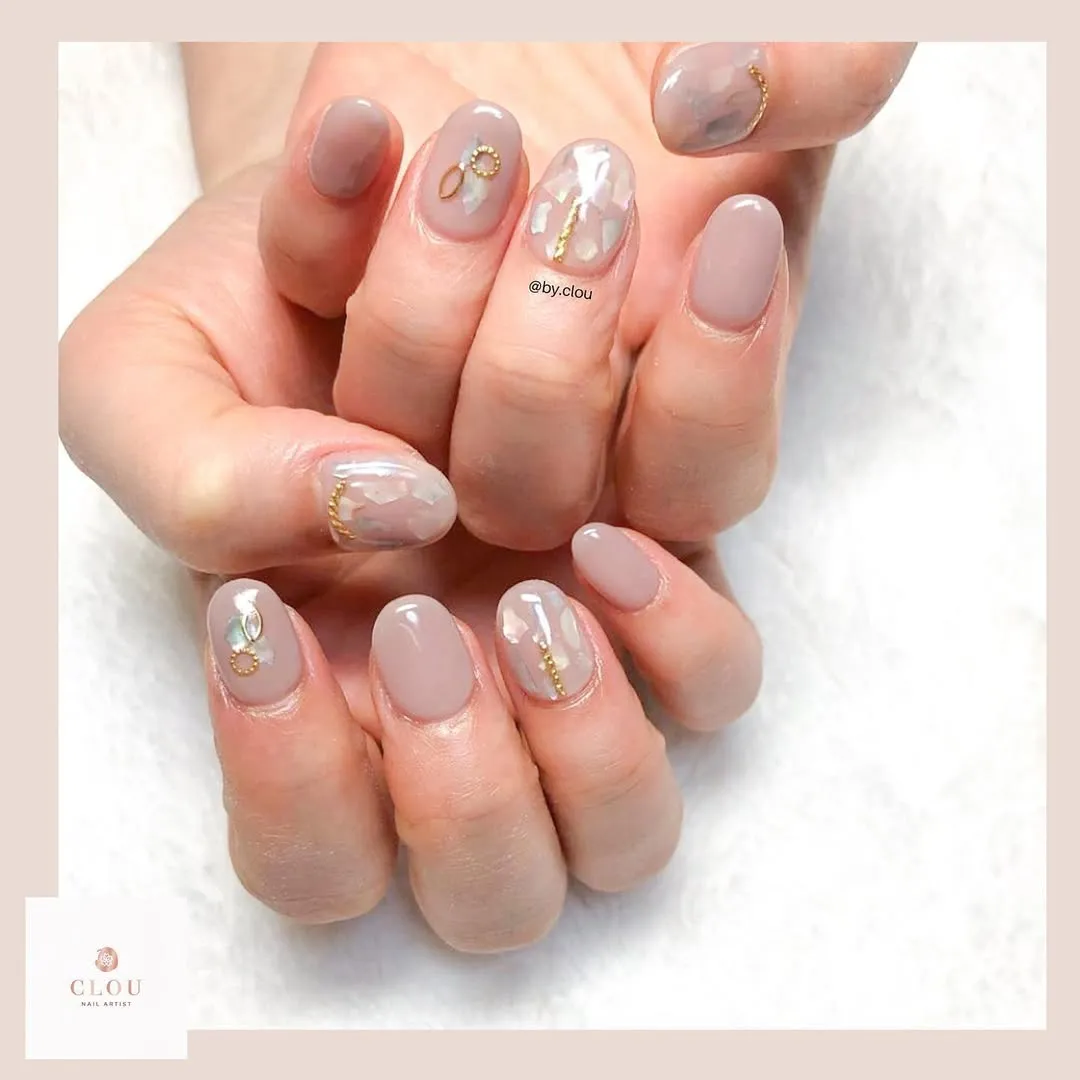 Grey-beige glossy nails with translucent marbling and gold accents