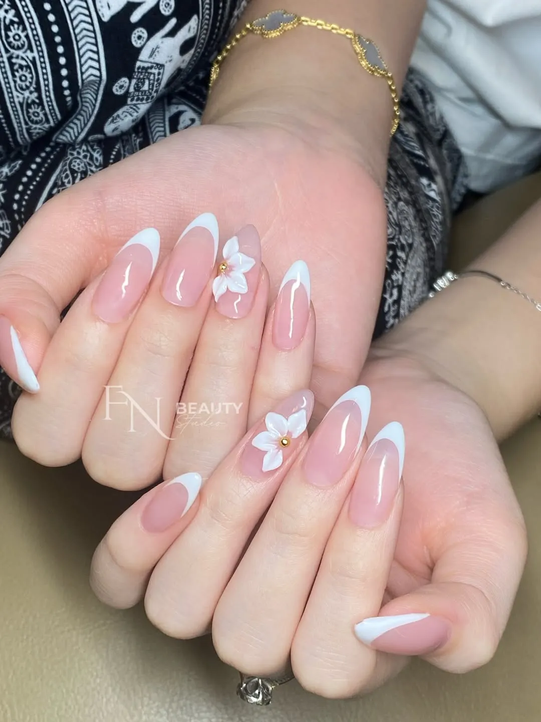 Long French tips with raised white flowers and gold centers