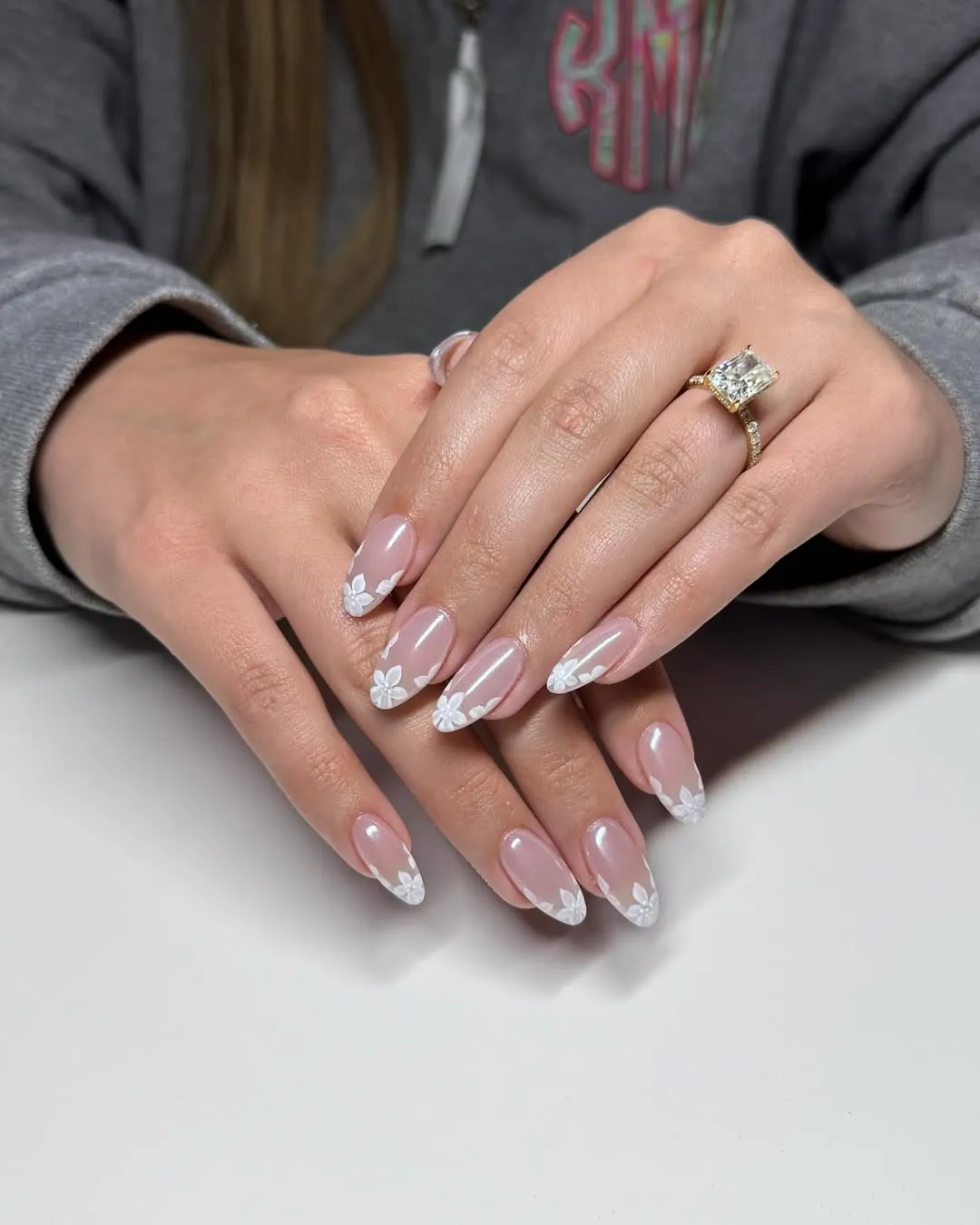 Nude almond nails with white floral tip detailing