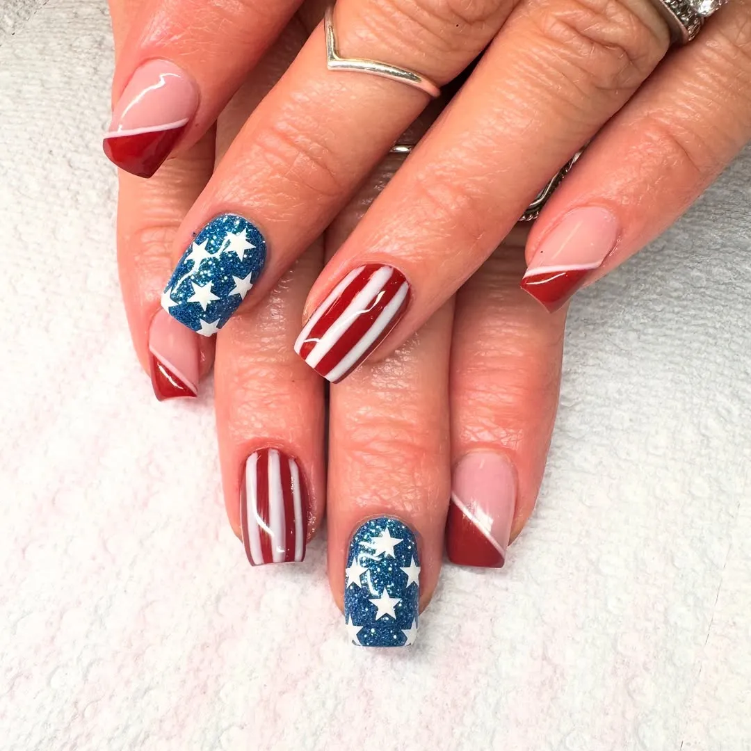 Diagonal red French tips with blue glitter star accents