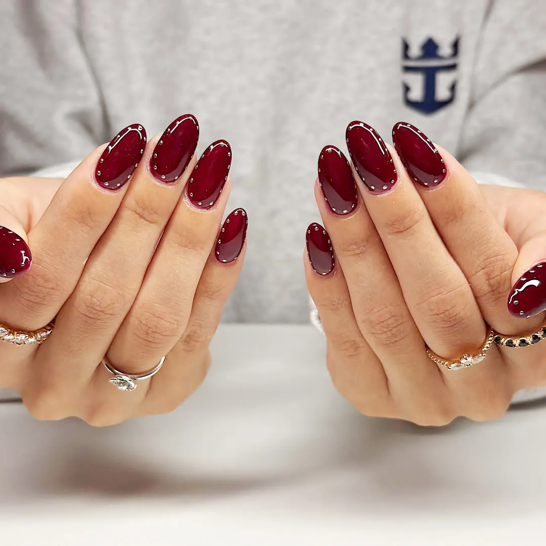 Deep cherry oval nails with perimeter stud detailing