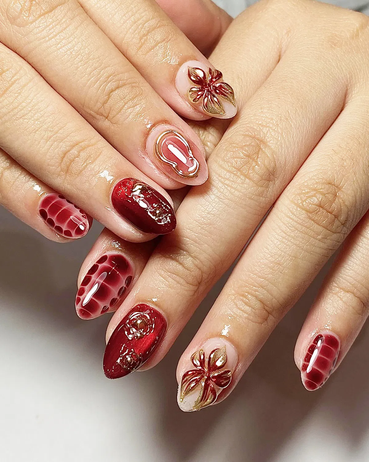 Almond cherry mix with gold floral accents and patterned nails