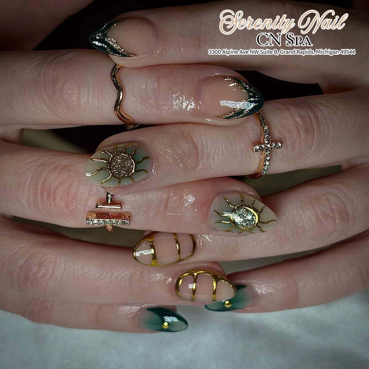 Green French tips with gold sun motifs and banded accents