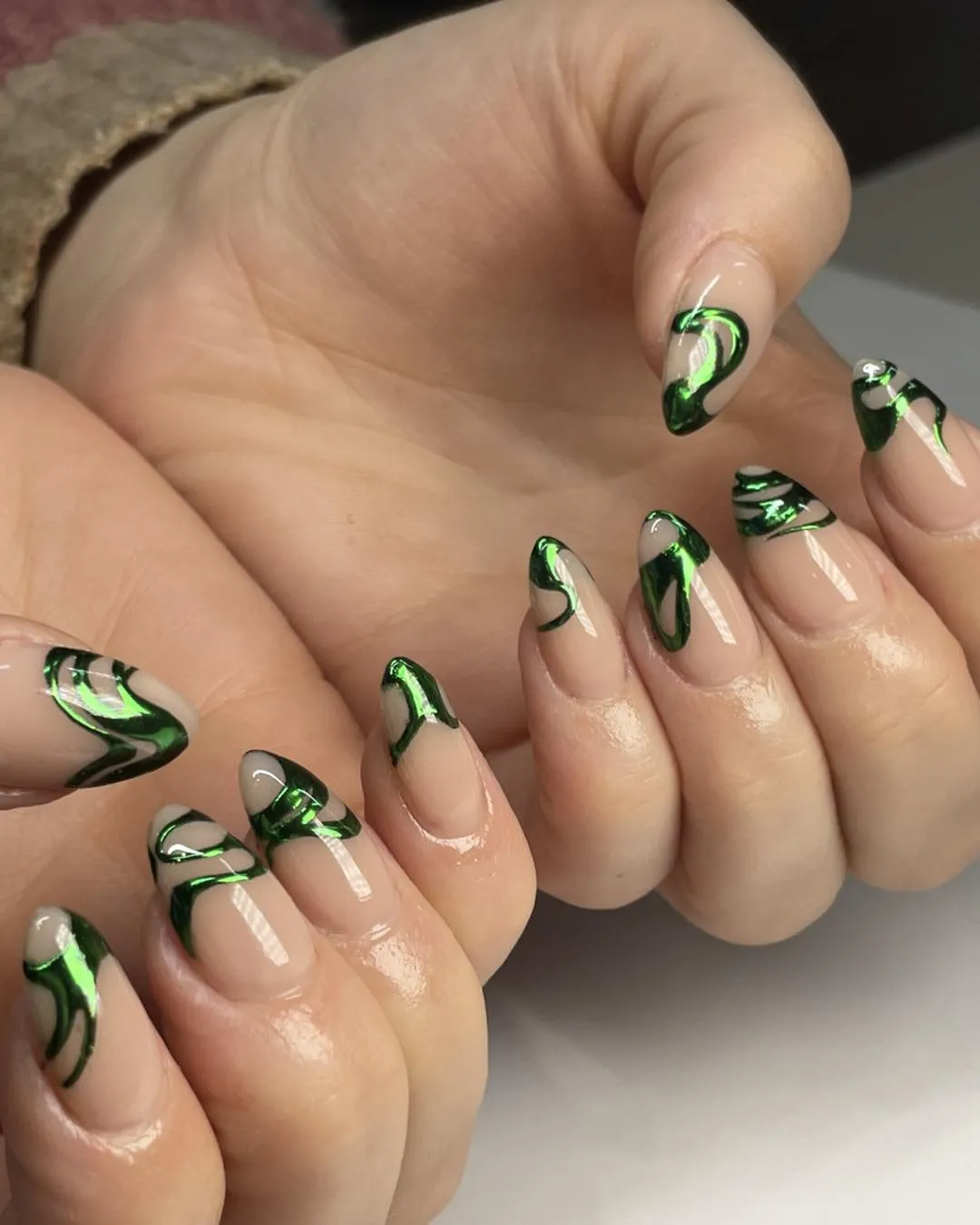 Nude base with reflective green swirl accents