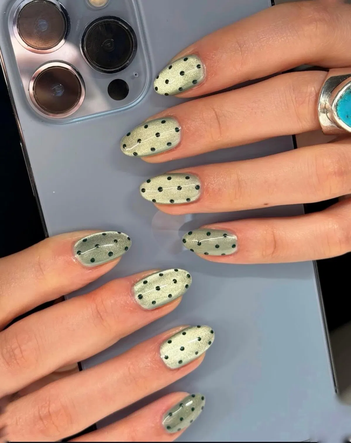 Metallic pale green nails with black polka dots
