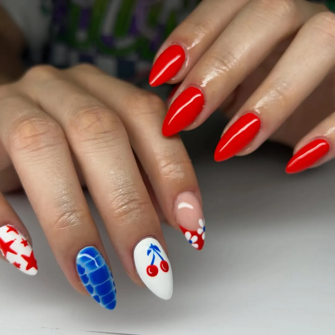 Solid red with star, blue pattern, and cherry accent nails