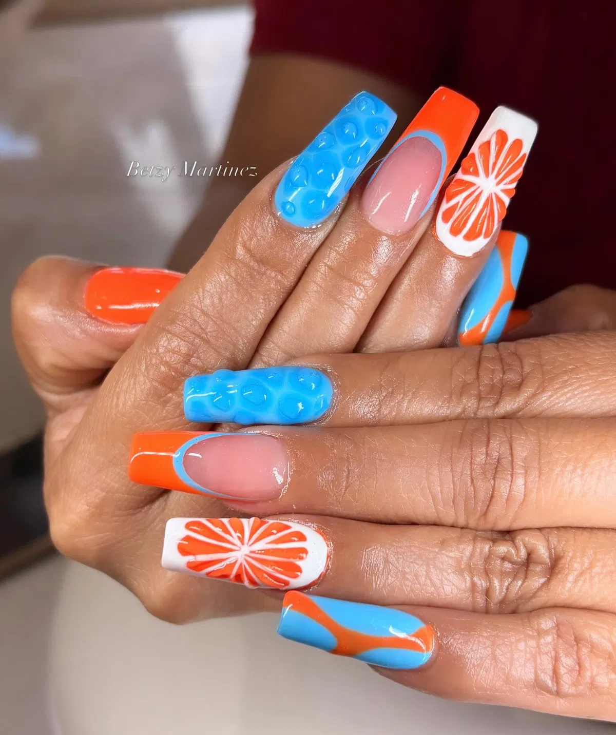 3D blue texture with orange French tips and citrus accents