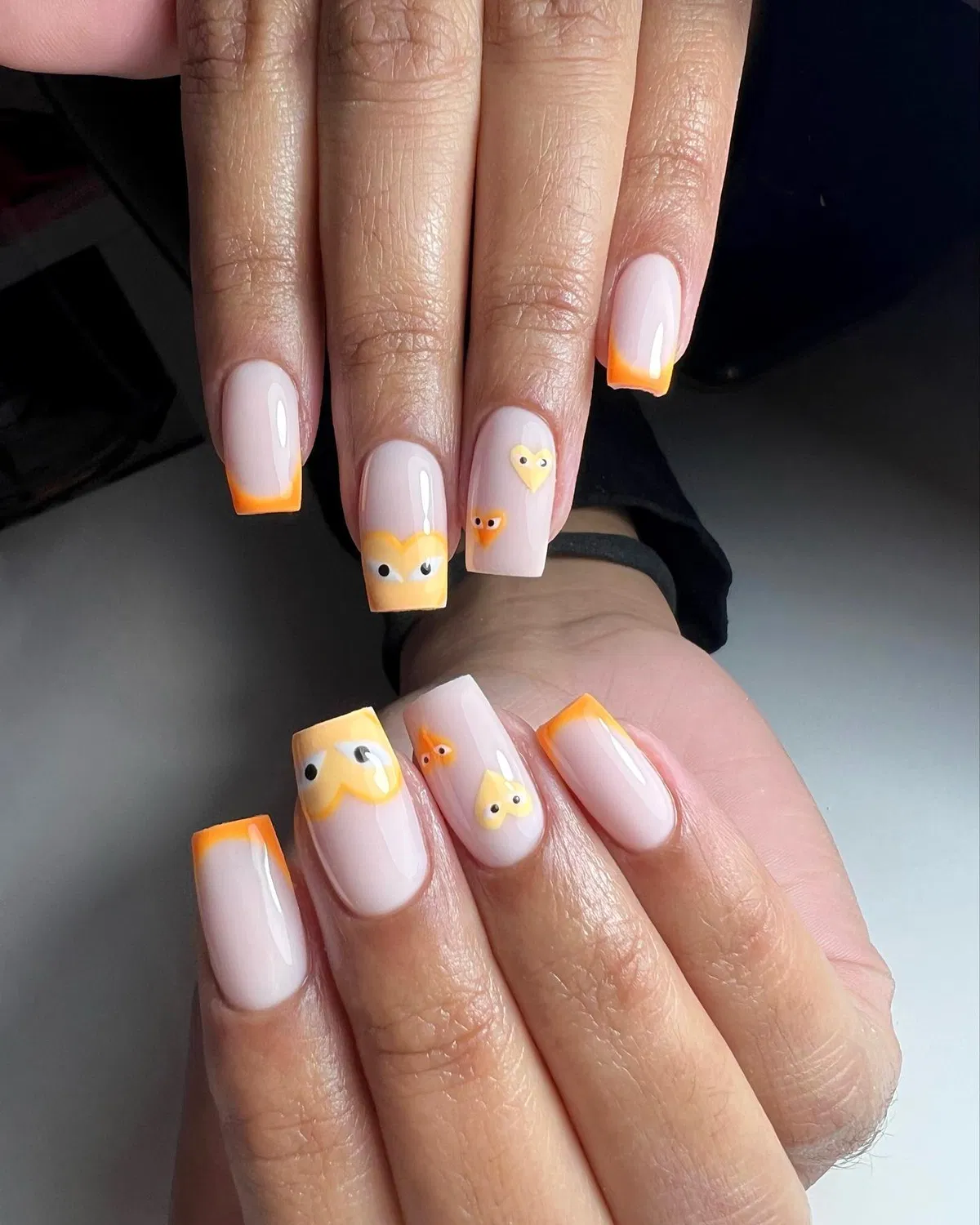 Thin orange French tips with playful face details