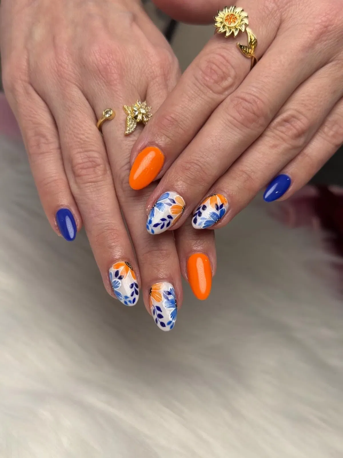 Orange and royal blue with white floral accent nails