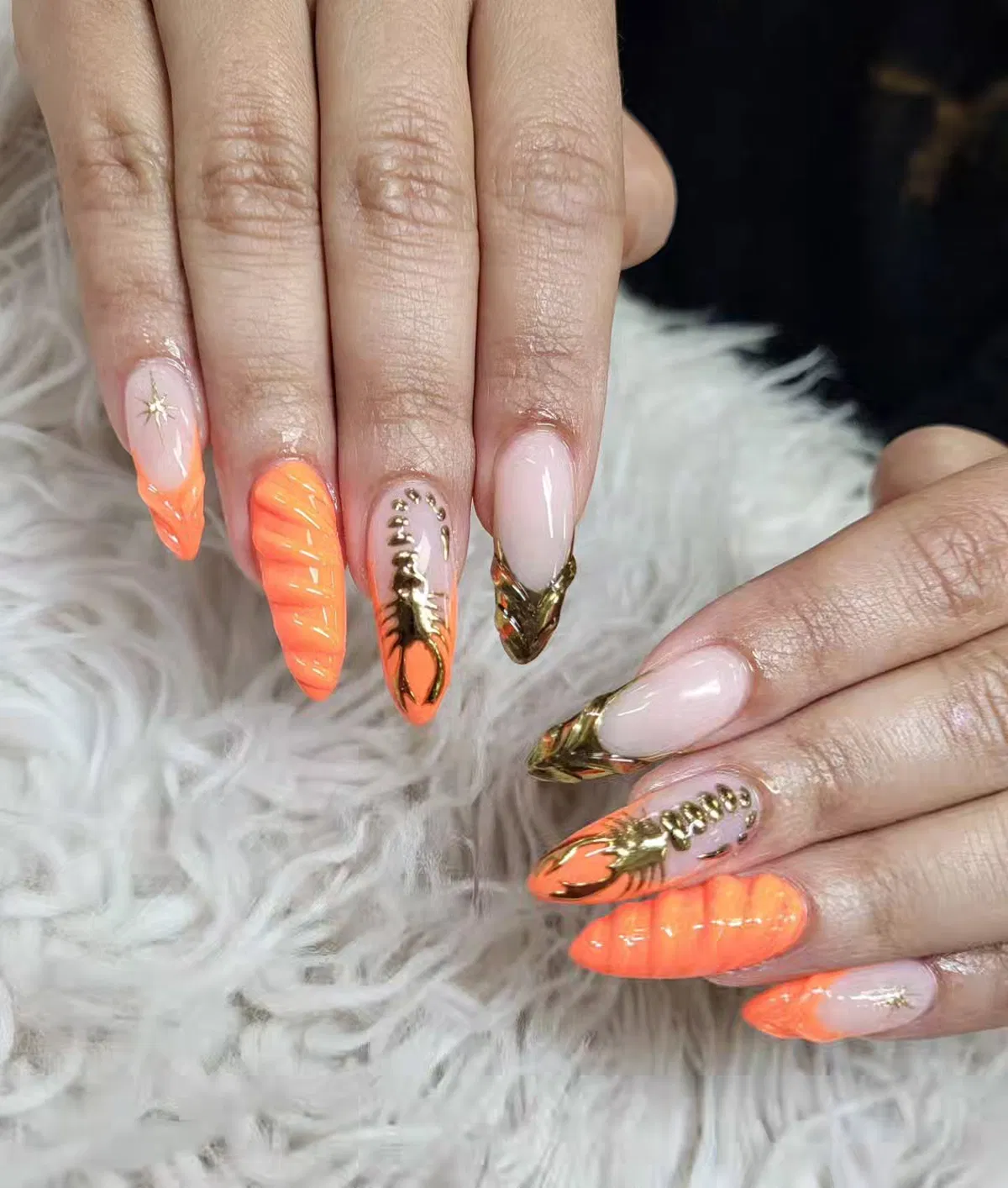 Textured orange stiletto nails with gold accents