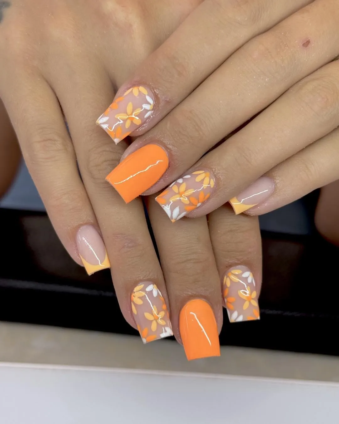 Bright orange solids with floral-pattern accent nails