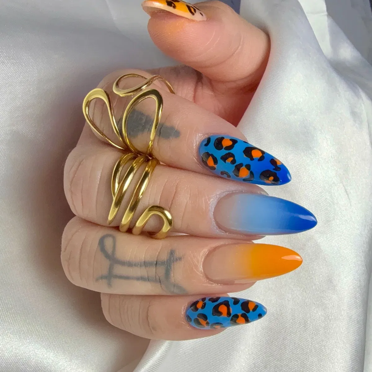 Blue leopard spots with orange centers and blue/orange ombrΓ© tips