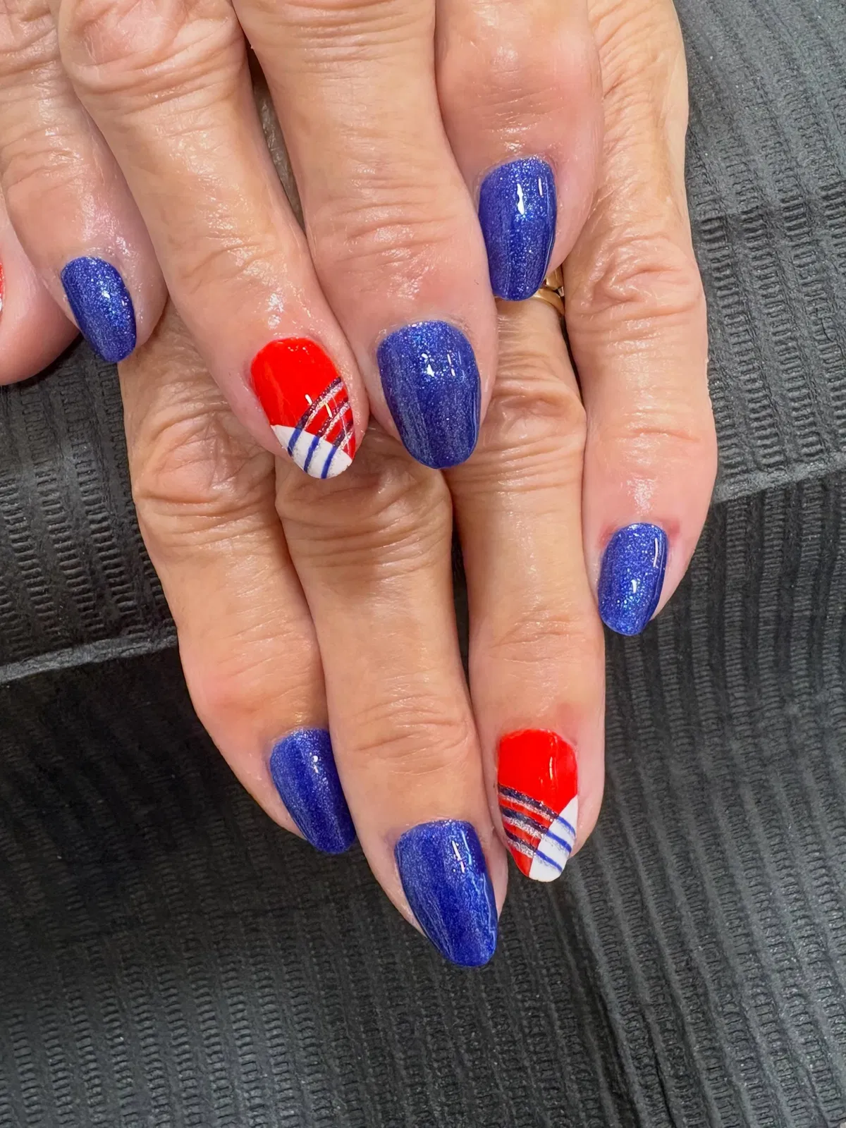 Shimmery deep-blue nails with red diagonal accents