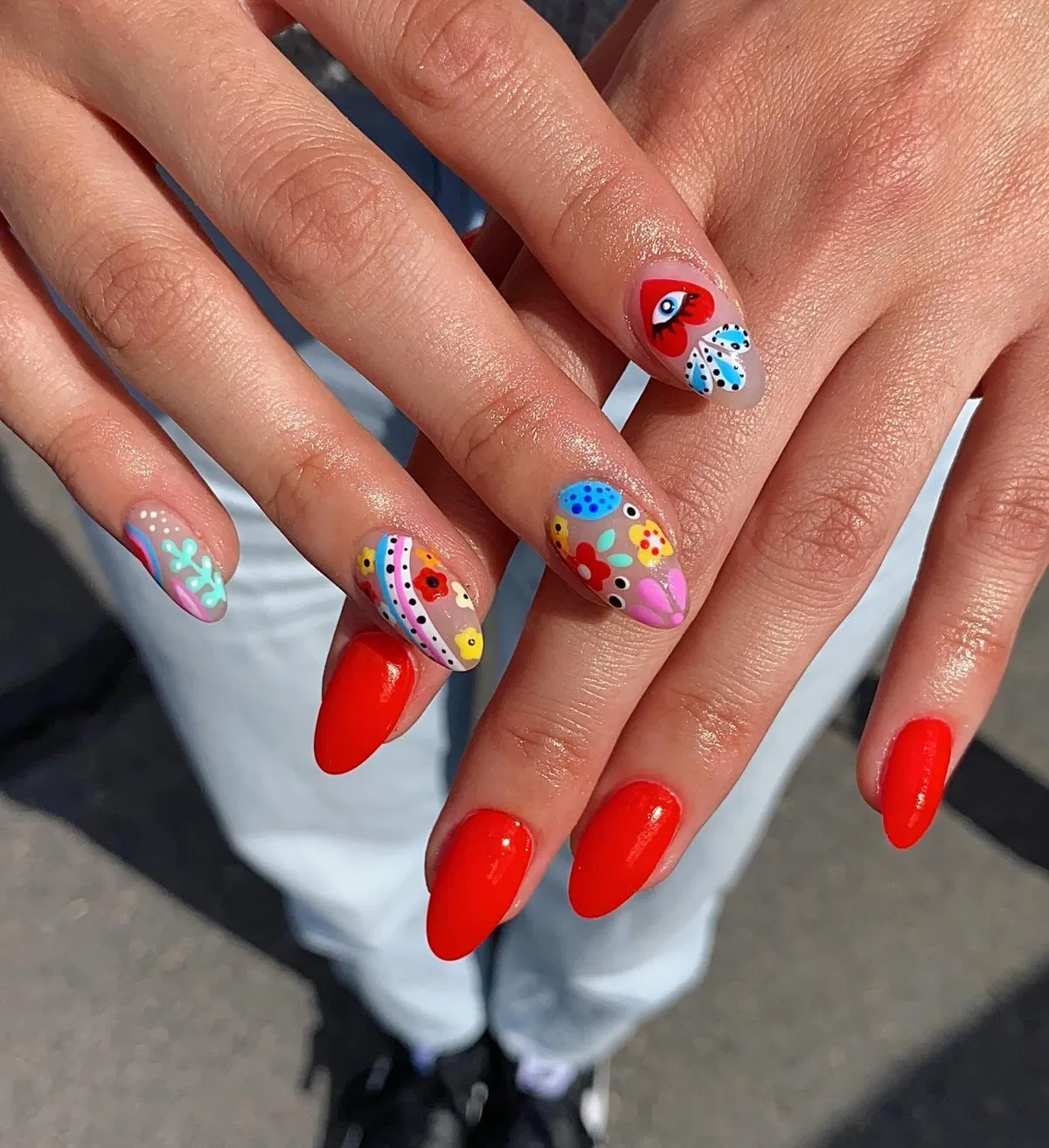 Red solids mixed with busy floral-and-dot accent nails