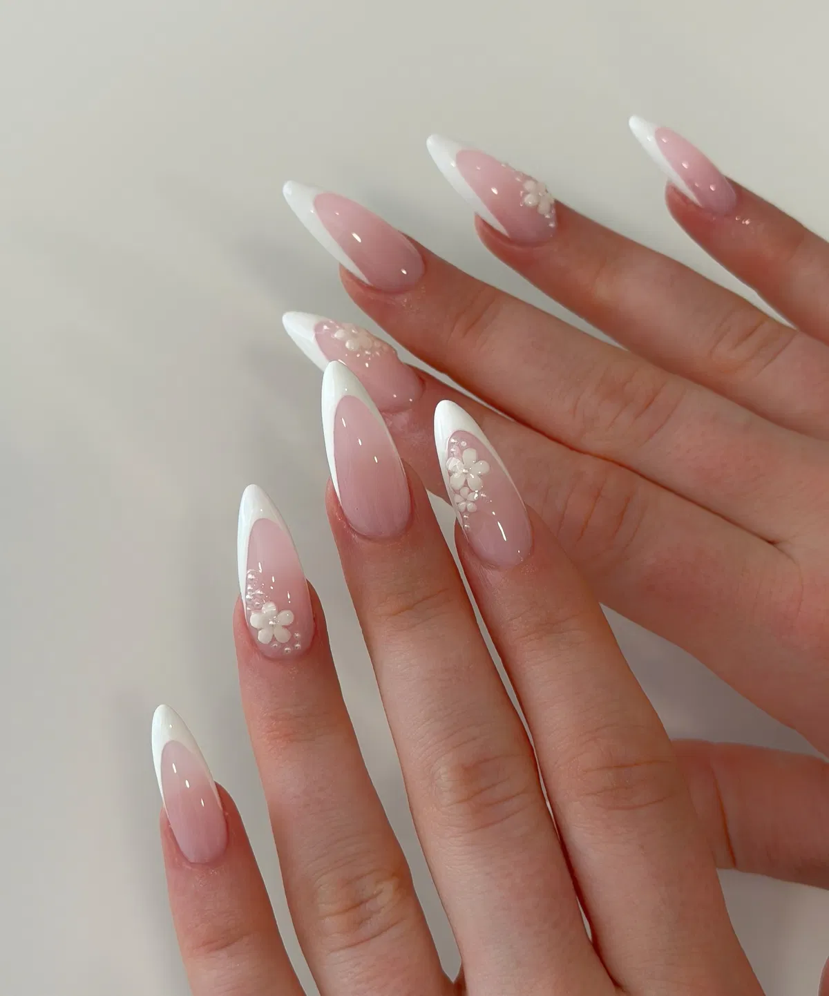 French almond nails with repeated 3D floral clusters