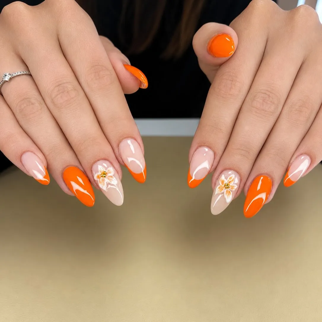 Orange French tips with white floral accents