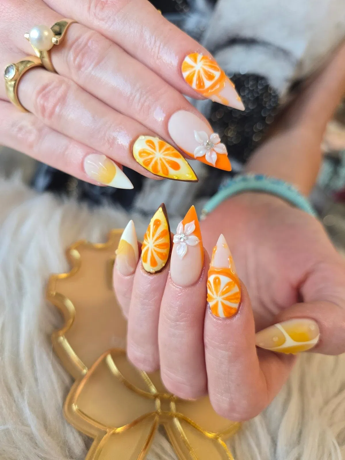 Citrus-slice nail art with orange tips and 3D white flowers