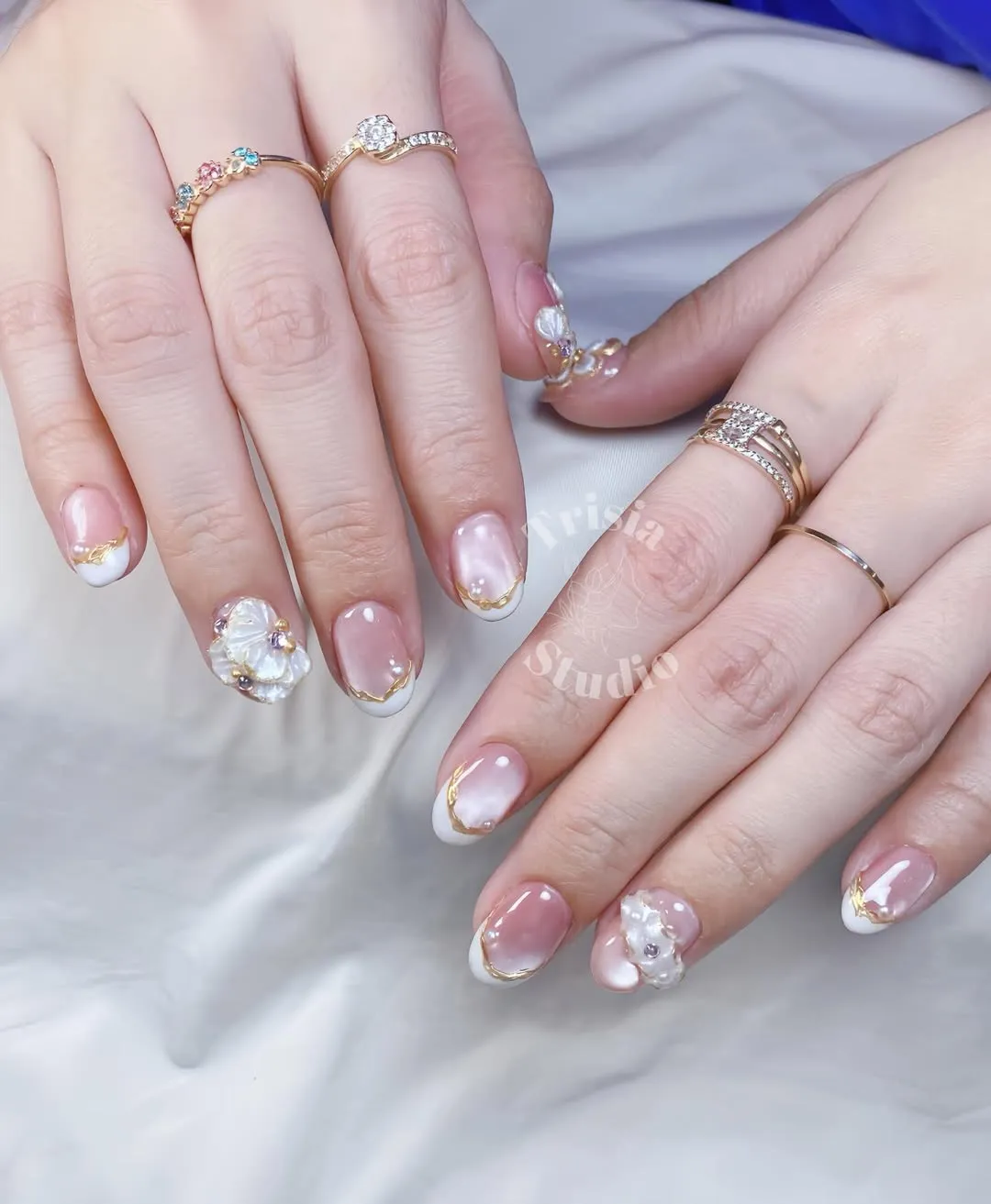 Pink French tips with gold edging and raised flower accents