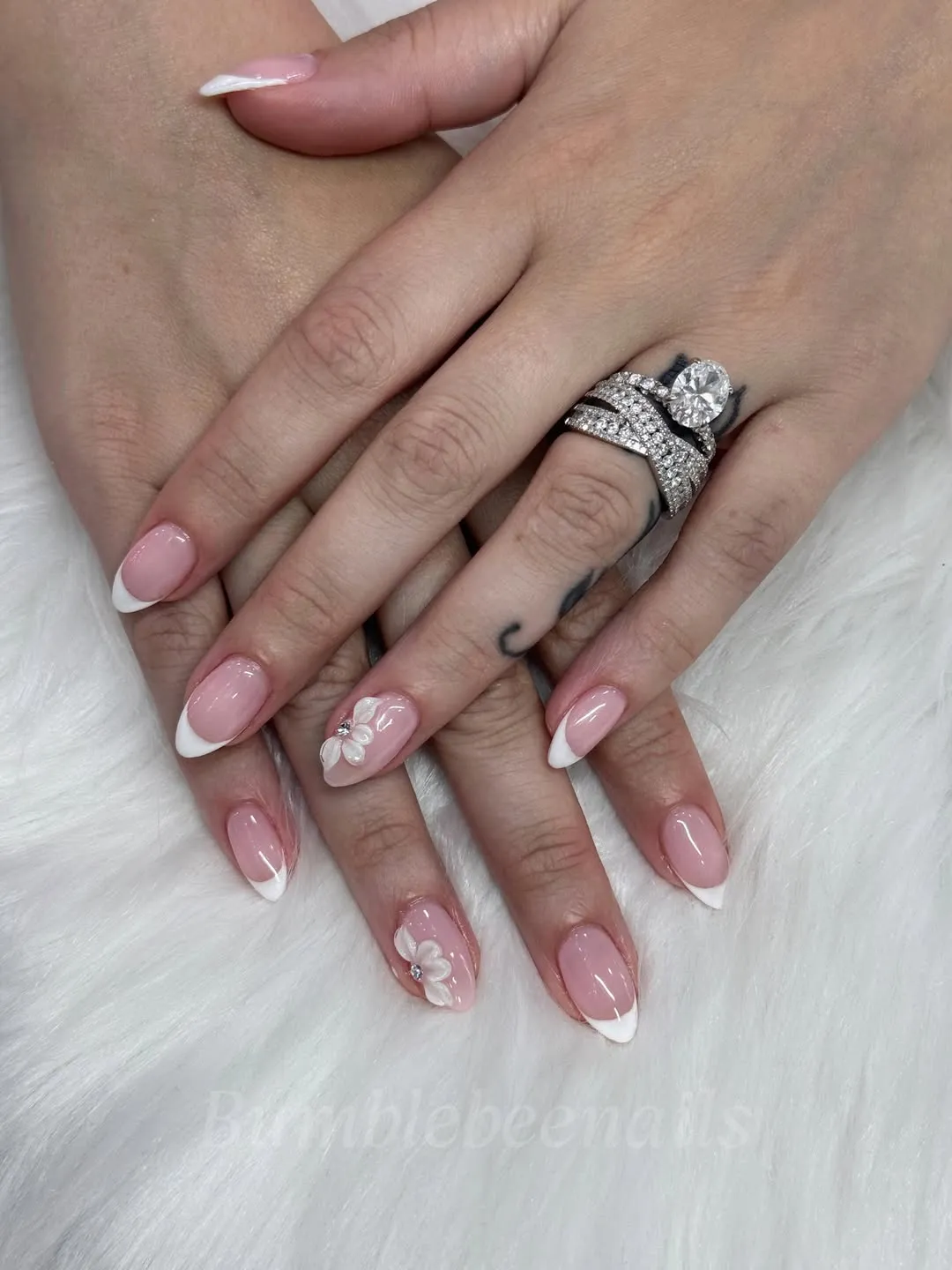 Pale pink French tips with raised floral accents