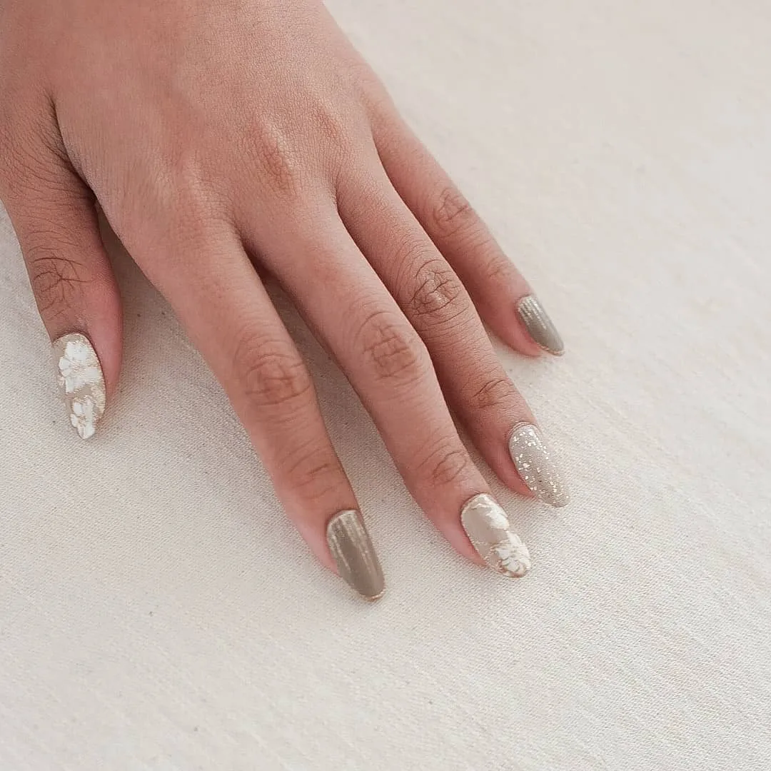 Metallic taupe/silver nails with nude glitter and raised floral accent