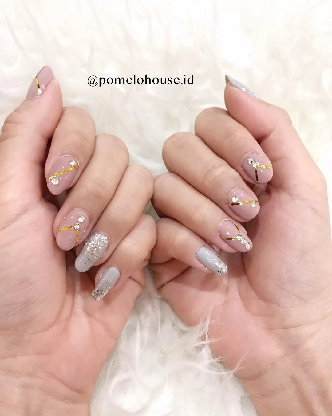 Nude nails with gold striping tape and silver glitter accents