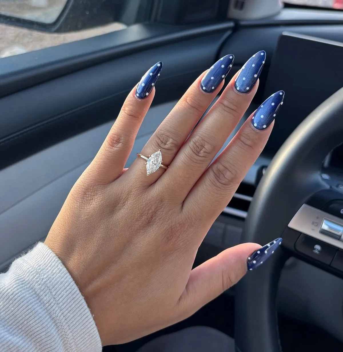 Long navy pointed nails with white polka dots
