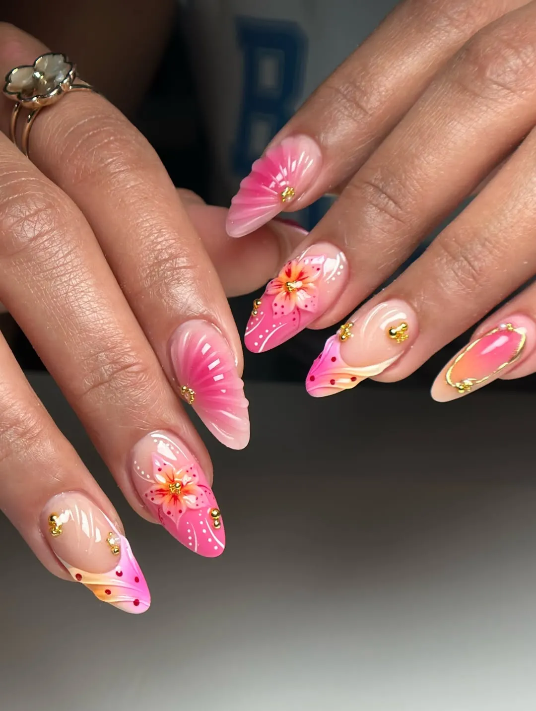 Pink floral nail art with gold bead accents