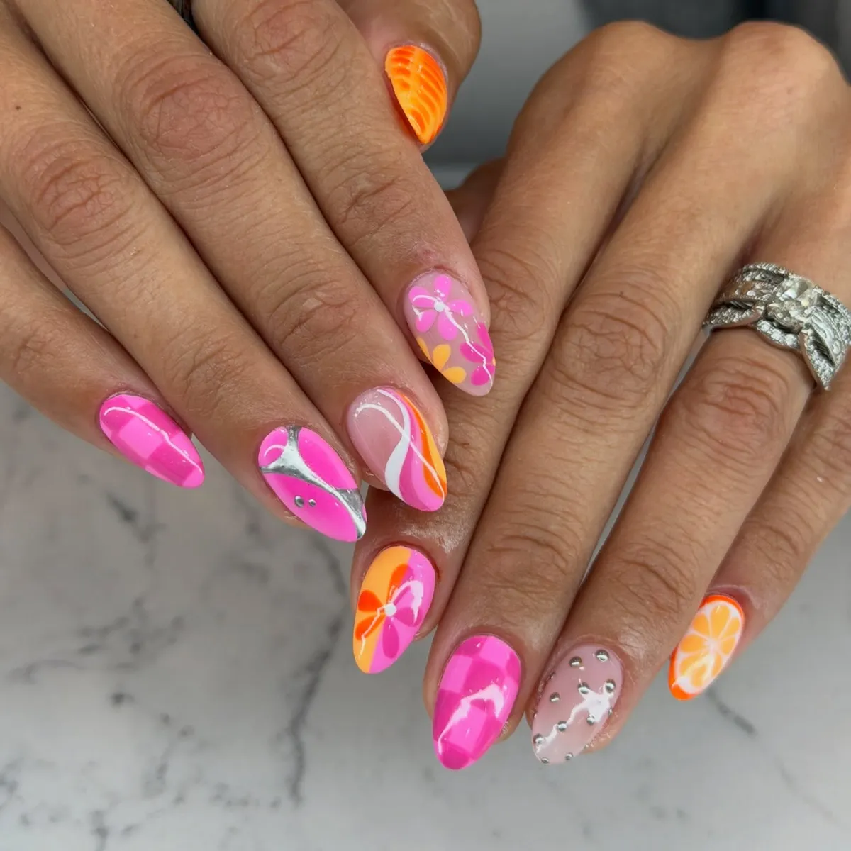 Mixed pink-orange set with florals, reflective curve, and citrus slice