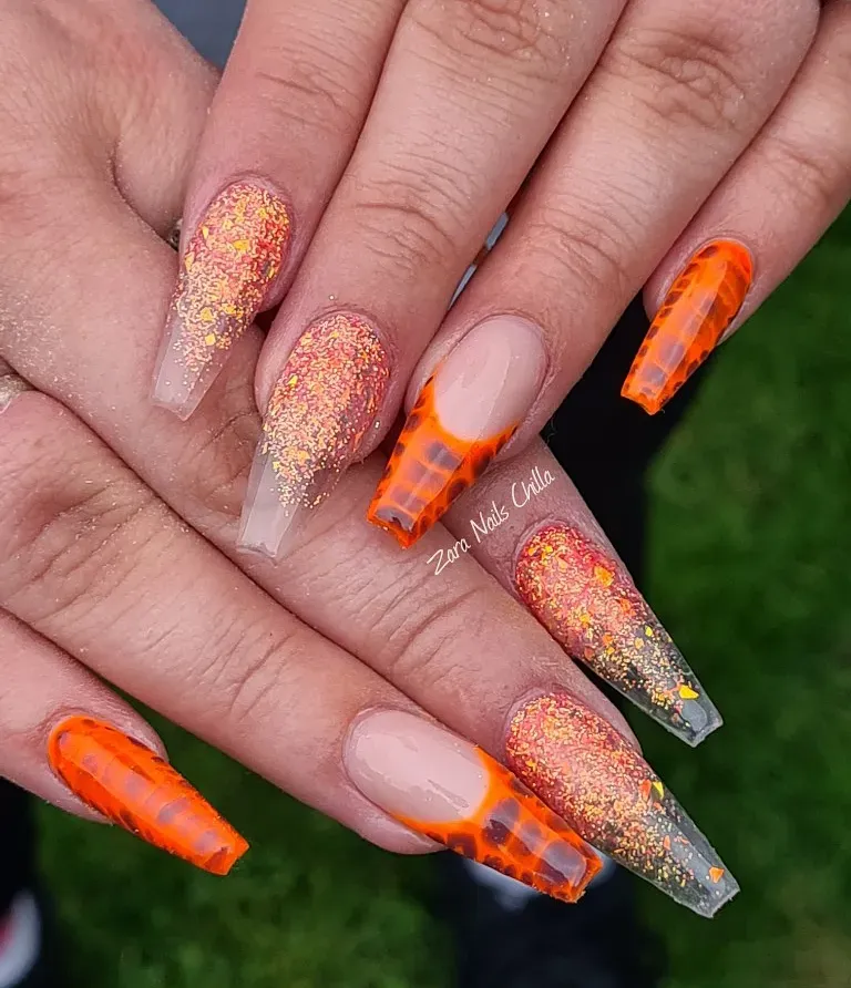 Orange marbled tips paired with orange-gold glitter gradients